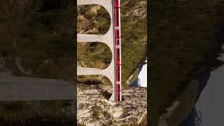 Landwasser viaduct a birds eye view as a Swiss train passes through train switzerland drone [upl. by Richara]