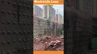 Construction vehicles work in sync breaking rocks and removing debris at a deep excavation site [upl. by Juta]