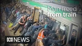 Faith in humanity restored as crowd lift train to save trapped man 2014  ABC News [upl. by Aisha]