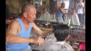 Chinese barber practising the rare art of cutting hair with hot tongs [upl. by Atinrahc]